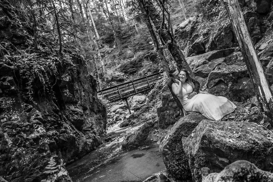 Couple assis sur un rocher devant une cascade