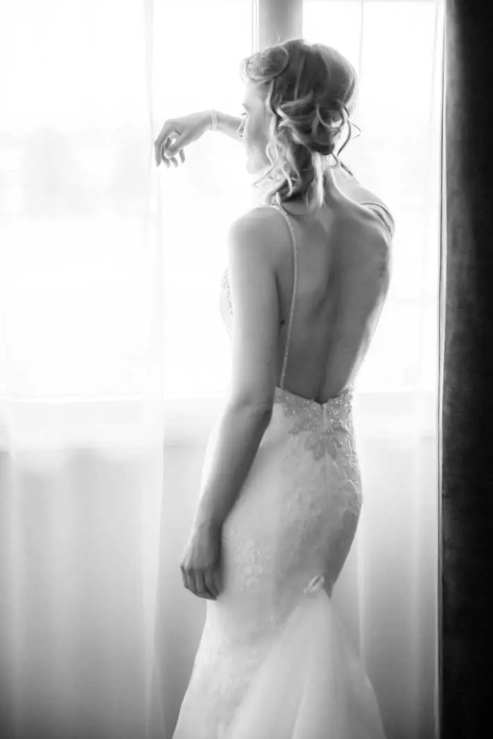 Mariée qui regarde dehors par la fenêtre