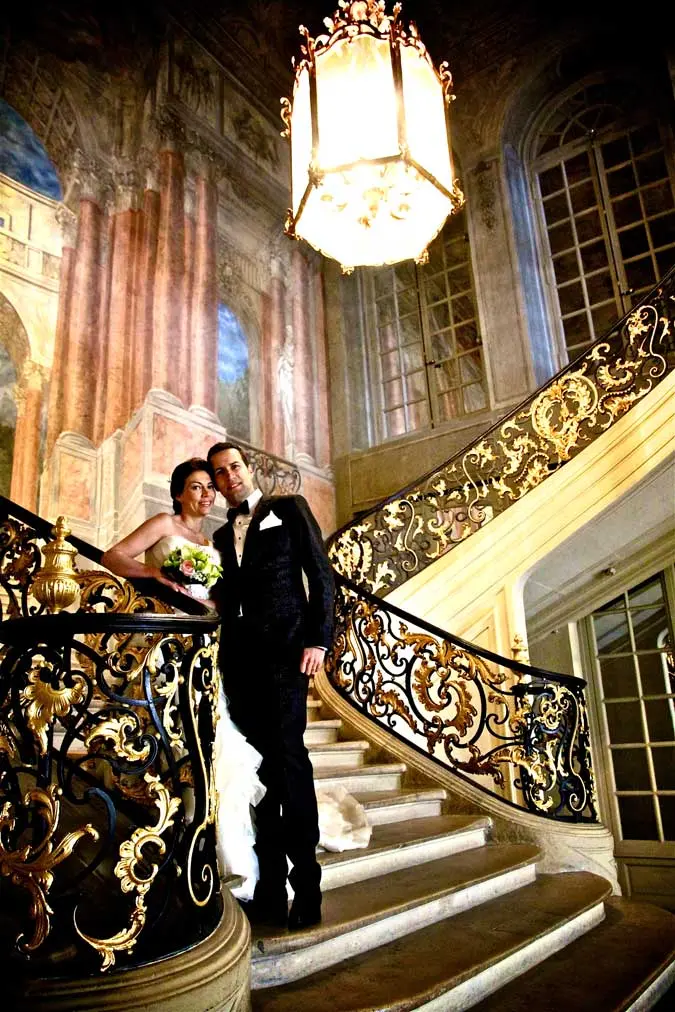 Couple dans des escaliers. Il y a un très grand luminaire