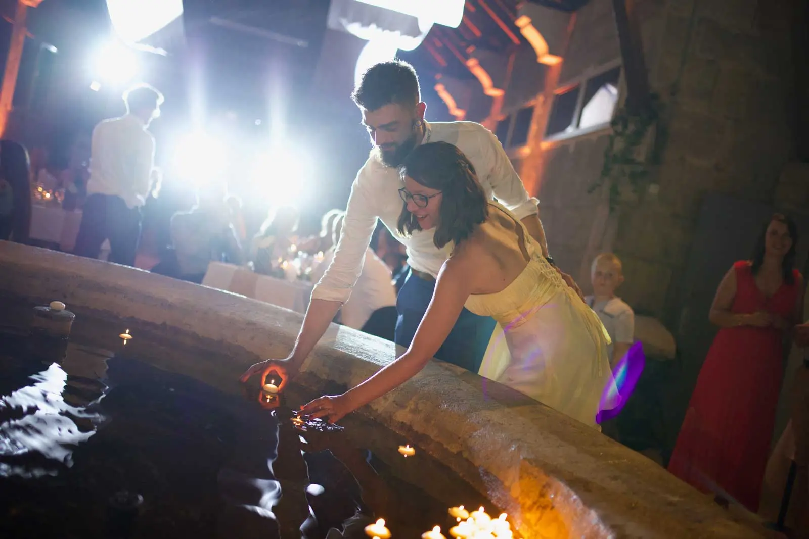 Couple qui pose une bougie sur l'eau d'une fontaine