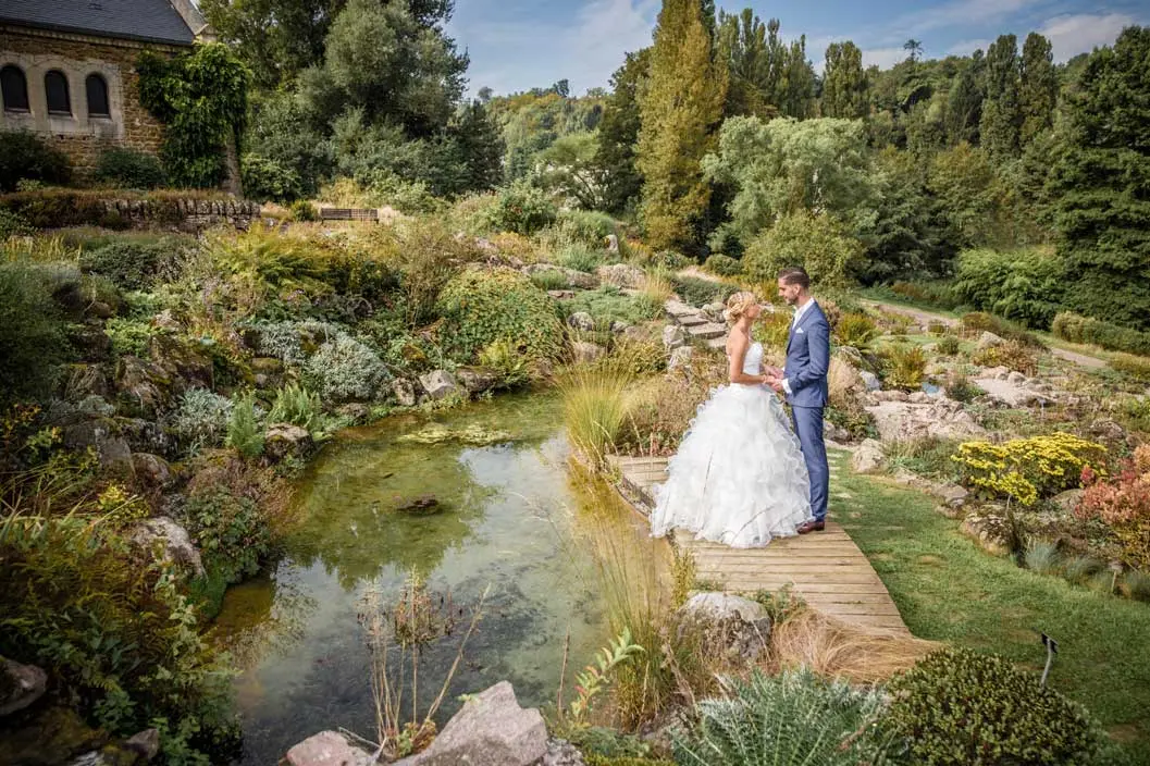 Un couple face a face dans un jardin . Il y a une chapelle au loin