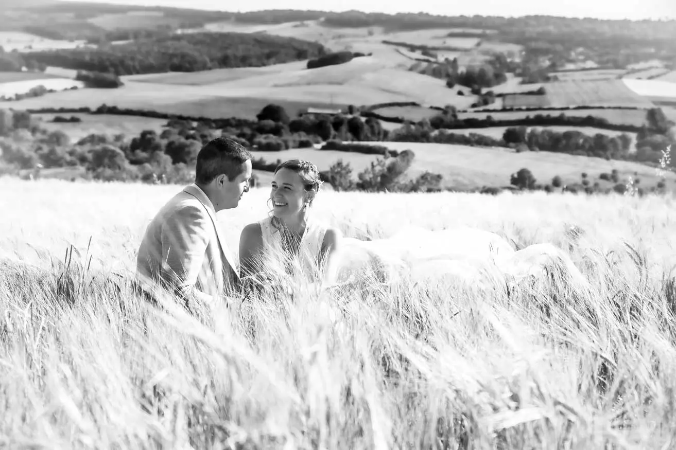 Un couple assis dans les champs de blé. Ils se regardent