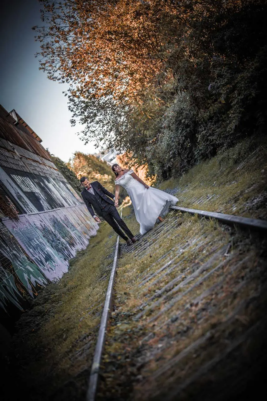 Couple qui marche sur des rails dans une zone urbaine