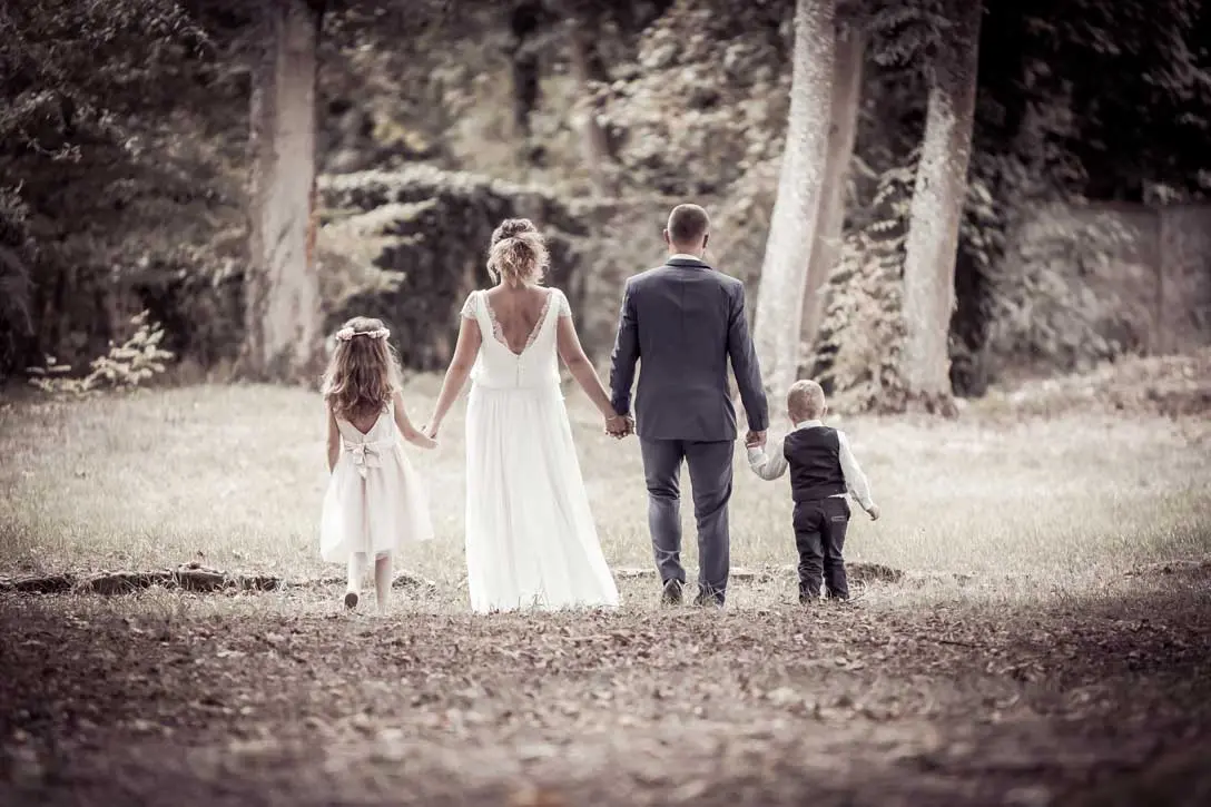 Couple marche dans une foret avec leur 2 enfants de chaque côté