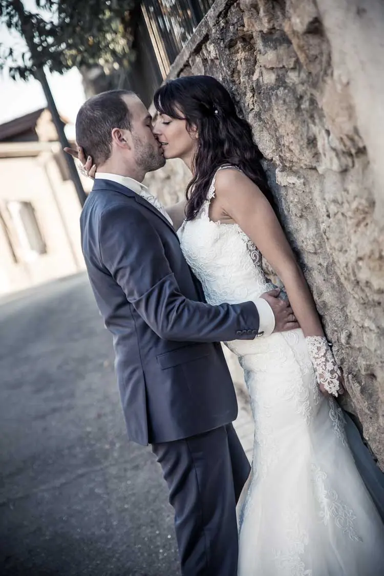 Couple qui s'embrasse contre un mur.