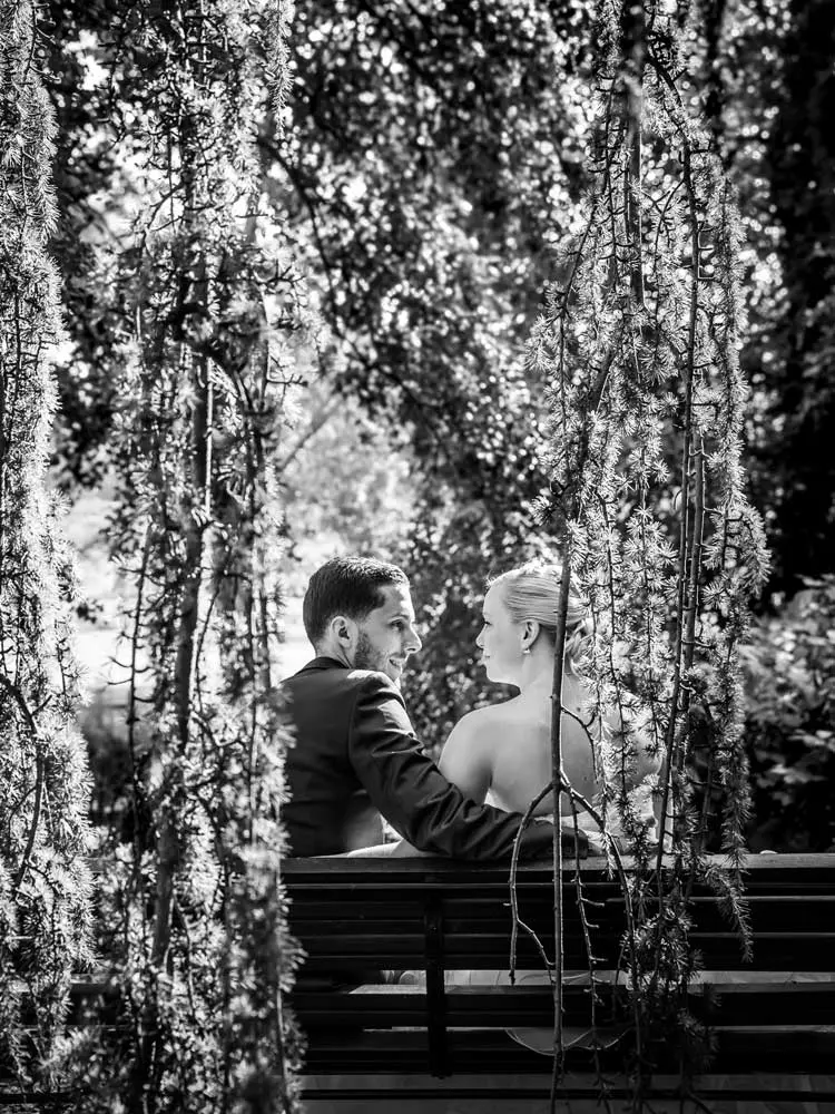 Couple se regarde dans un jardin ils sont assis sur un banc