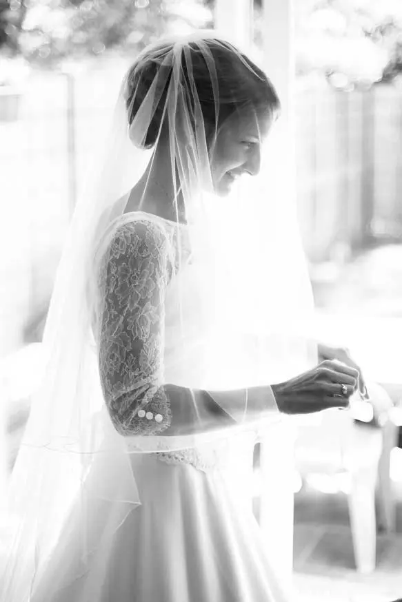 Une mariée se prépare chez elle, elle à un voile sur le visage